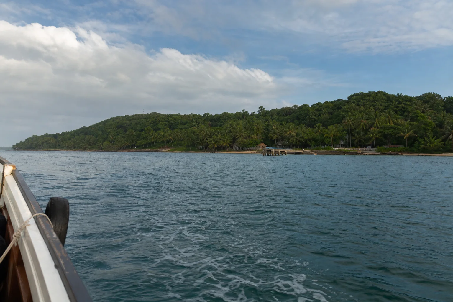 Approche en bateau d’une île tropicale évoquant Sainte-Marie à Madagascar